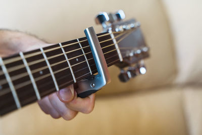 Cropped hand of man preparing guitar in home