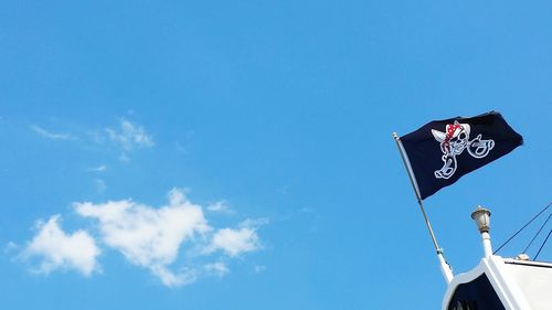 Low angle view of pirate flag against sky