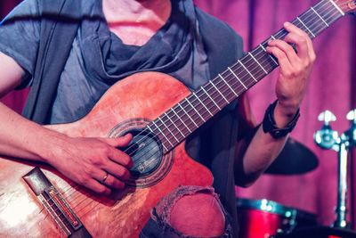 Low section of man playing guitar