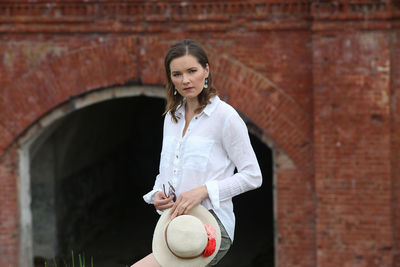 Portrait of woman standing against wall