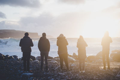 Rear view of silhouette people standing on beach