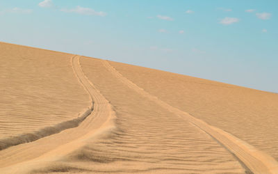 Sand dunes in desert against sky