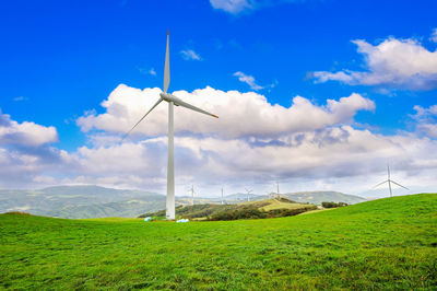 Windmill on field against sky