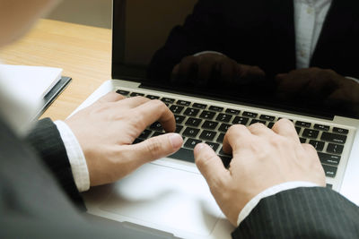 Midsection of man using mobile phone