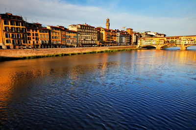 Ponte vecchio over arno river in tuscany against sky