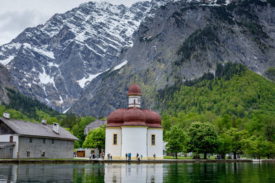 Scenic view of lake by buildings against mountains