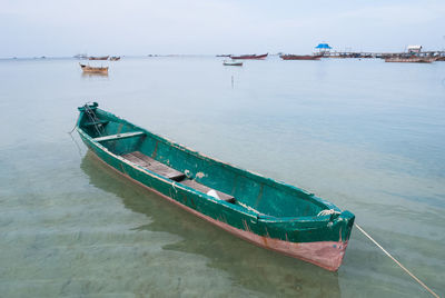 Boat moored on sea against sky