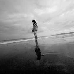 Women standing on beach against sky