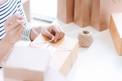 Midsection of woman holding paper