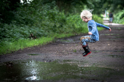 Full length of boy running in water