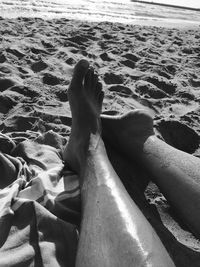 Low section of man relaxing on beach