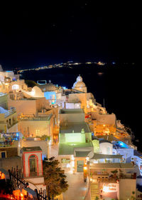 Illuminated buildings in city against sky at night