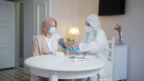 Doctor wearing mask examining patient