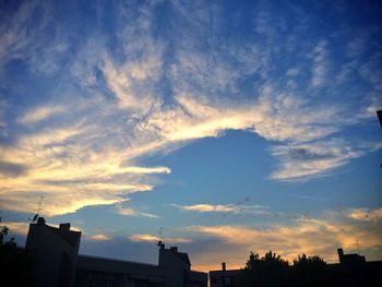 Low angle view of buildings against sky at sunset