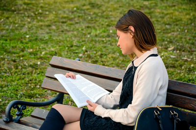 Woman sitting on bench in park