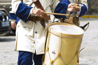 Midsection of man playing drum