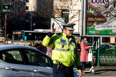 Man standing on car in city