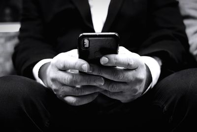 Midsection of man using mobile phone