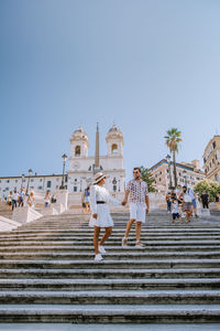 Low angle view of couple holding hands against sky