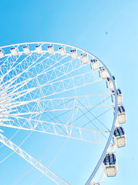 Low angle view of ferris wheel against blue sky