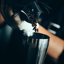 Close-up of hand pouring coffee