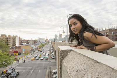 Side view of young woman looking at cityscape