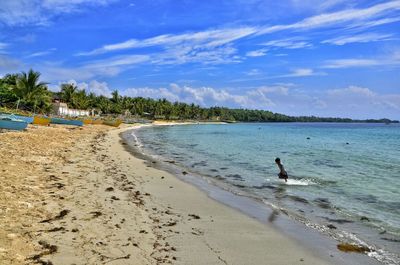 Scenic view of beach against blue sky