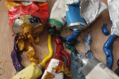 High angle view of colorful paints with tubes on table at workshop