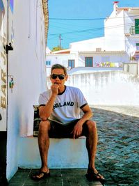 Full length of man sitting on sunglasses