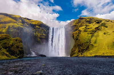 Scenic view of waterfall against sky