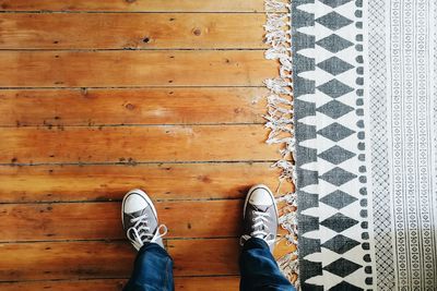 Low section of person standing on tiled floor