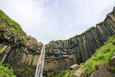 Low angle view of cliff against sky