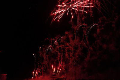 Low angle view of firework display at night