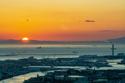 High angle view of townscape by sea against romantic sky