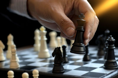 Cropped hand playing chess at home