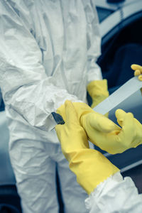 Cropped hand of person assisting coworker is wearing workwear