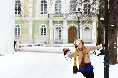 Portrait of woman holding pole on snow covered field