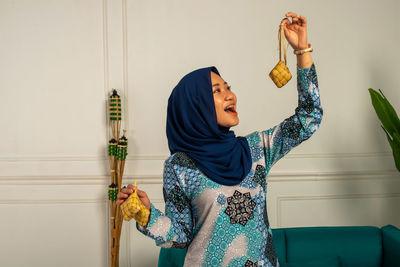 Woman standing against wall at home