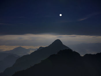 Scenic view of silhouette mountains against sky at night