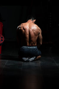 Low section of man sitting on hardwood floor