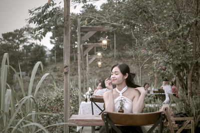 Side view of woman drinking water in park