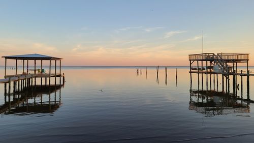 Pier on sea against sky during sunset