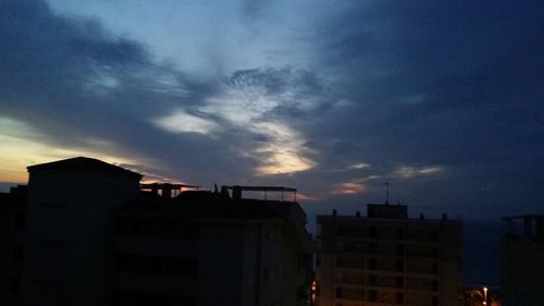 Low angle view of buildings against cloudy sky