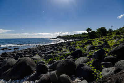 Rocks by sea against sky