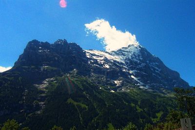 Scenic view of mountains against blue sky