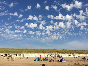 People on beach against blue sky