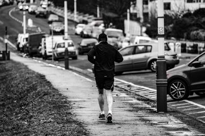 Rear view of man walking on railroad track