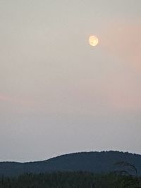 Scenic view of landscape against clear sky at dusk