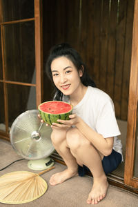 Portrait of young woman sitting on table