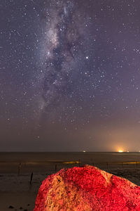 Scenic view of sea against star field at night